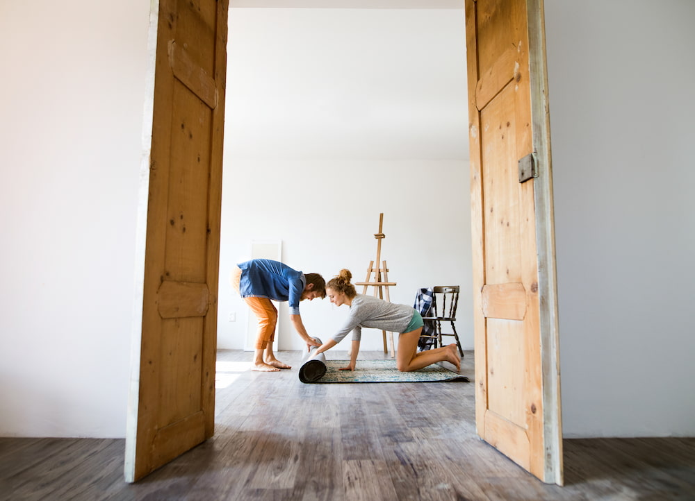 couple unrolling a rug- using moving tips