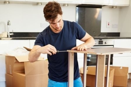 man disassembling furniture